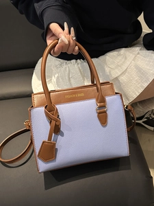 Blue and brown color-block leather tote bag with elegant top handle and gold lettering