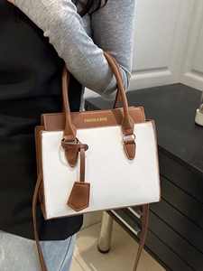 Elegant white and brown contrast tote bag with golden lettering and crossbody strap