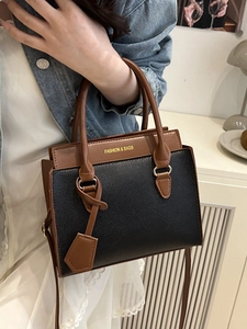 Fashion tote bag with black and brown leather stitching and adjustable shoulder strap