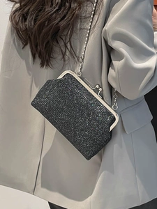 Sac à bandoulière en paillettes noires avec chaîne argentée porté par un mannequin