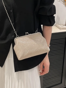 Sac à main doré brillant avec bandoulière chaîne porté en travers pour soirée élégante