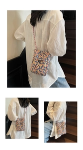 Detailed view of floral canvas phone bag with drawstring closure and pink woven strap