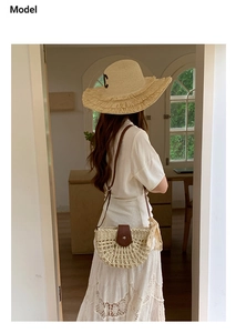 Detail of woven straw handbag and matching sun hat set on a white dress for summer vacations