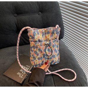 Macro view of floral knit phone bag texture with drawstring pocket and shoulder strap