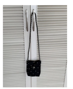 Détail du sac bandoulière noir à pois avec fermoir rotatif argenté et sangle