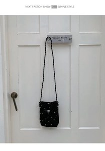 Détail du sac nuage noir avec broderie d'étoiles et bandoulière tressée chic