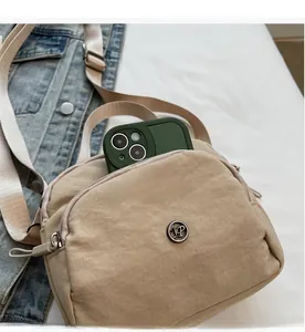 Macro shot of large capacity nylon handbag with multiple zipper pockets and logo