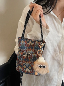 Colorful geometric checkered chest bag with woven handle and plush monster pendant