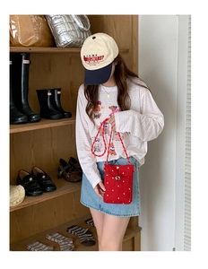Détail du petit sac bandoulière en toile rouge à pois avec bandoulière en cordelette