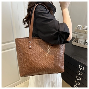 Brown woven tote bag side view showing shoulder strap fit and large storage capacity