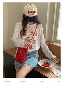 Détail d'un t-shirt blanc en coton avec chiens de dessin animé et sac bandoulière à pois