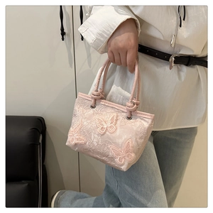Close-up of pink lace bucket bag with 3D butterfly embroidery and elegant top handle