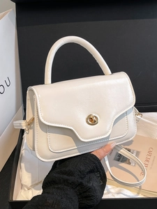 Elegant white trapezoid handbag with gold twist lock and adjustable shoulder strap