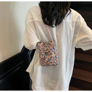 Detailed back view of a small floral crossbody bag with rope strap and drawstring pocket