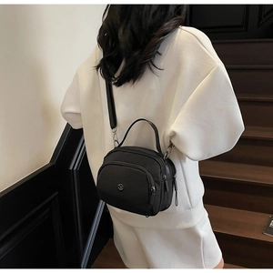 Practical multi-pocket black nylon handbag shown being worn as a crossbody bag