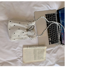 Détail de la pochette plissée à fleurs blanches avec cordon et bandoulière corde