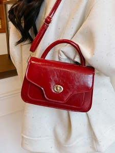 Glossy red faux leather handbag with gold ring clasp and adjustable strap for women