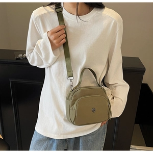 Detailed side view of an olive green nylon crossbody bag with adjustable wide shoulder strap