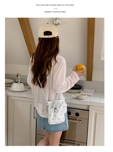 Photo lifestyle d'un sac seau en toile à pois blancs porté avec une tenue d'été décontractée
