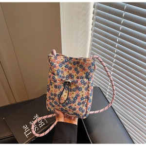 Detail of floral mini crossbody bag with drawstring pocket and pink rope shoulder strap