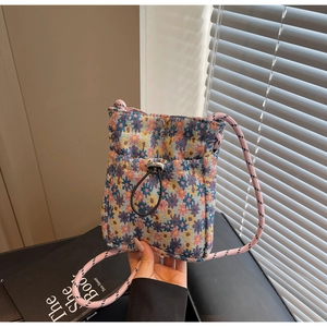 Close-up of floral tapestry crossbody phone bag featuring a woven strap and metal buckle