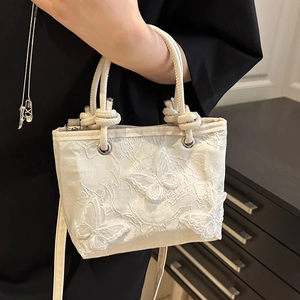 Elegant white embroidered butterfly bucket bag with stylish twisted rope handles