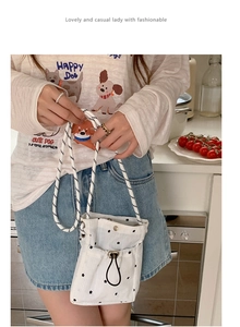 Détail d'un sac nuage en toile blanche à fleurs avec cordon et bandoulière en corde