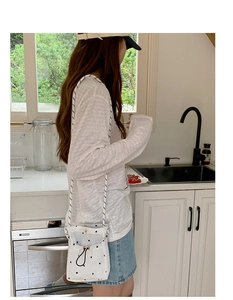 Vue détaillée du sac en toile blanche à motif d'étoiles avec cordon et bandoulière tissée