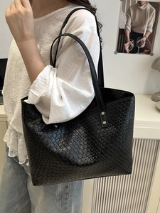 Large black woven leather tote bag with silver rivets and dual shoulder straps