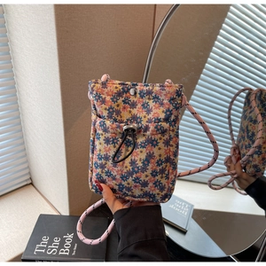 Detail view of floral jacquard fabric phone bag with drawstring pocket and pink strap