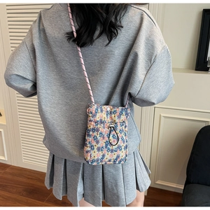 Floral canvas crossbody bag with drawstring closure and colorful braided rope strap