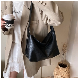 Lifestyle shot of a black oversized PU leather tote bag with a vintage pleated texture