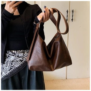 Detail of vintage dark brown faux leather tote bag with wide adjustable shoulder strap