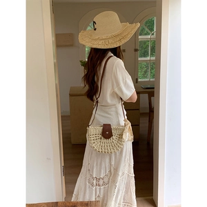 Handwoven hollow semi-circle straw bag with brown leather flap for resort style