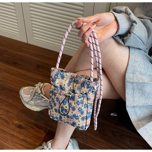 Detailed macro shot of a floral woven crossbody phone bag with a drawstring front pocket