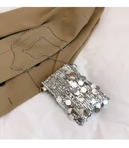 Close-up of silver sequin mini crossbody bag featuring a delicate metal chain strap