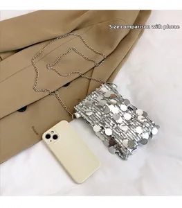 Silver sequin mini crossbody bag shown with a smartphone for size reference