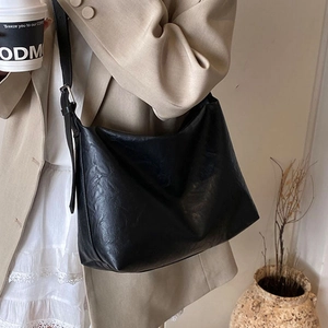 Chic black large capacity vintage tote bag worn by a model in a minimalist French style