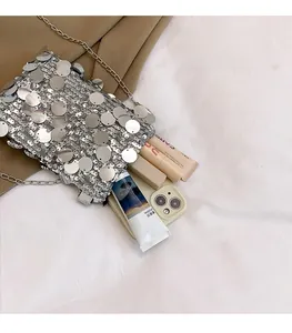 Flat lay of silver sequin crossbody bag showing interior capacity for phone and cosmetics