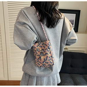 Floral crossbody phone bag with drawstring front pocket and pink woven strap detail