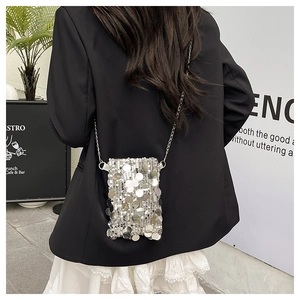 Close-up of silver sequin crossbody bag with chain strap and reflective mirror finish