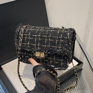 Classic black tweed crossbody bag with gold chain strap and turn-lock closure