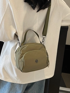 Olive green nylon crossbody bag with adjustable wide strap and dual zipper compartments
