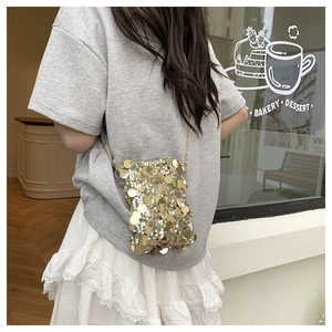 Close-up of a stylish gold sequin mini square bag with a thin metallic chain strap