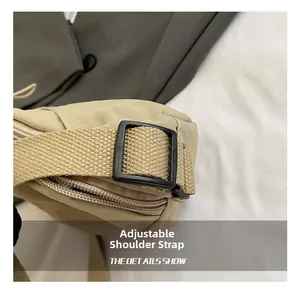 Close-up of adjustable black plastic buckle and woven shoulder strap on beige bag