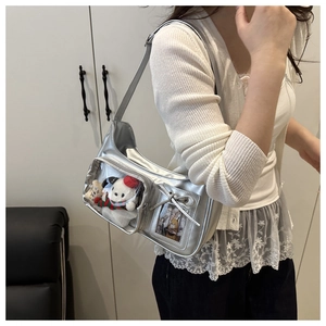 Détail du sac ita argenté avec fenêtre transparente, peluche et porte-carte à nœud