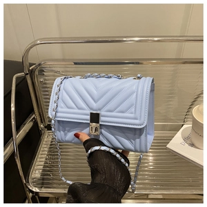 Détail du sac matelassé bleu clair avec chaîne argentée et fermoir rotatif métallique