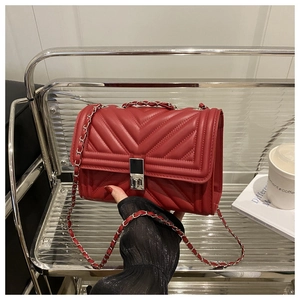Détail du sac bandoulière rouge matelassé avec fermoir argenté et bandoulière chaîne