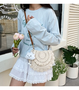 Detail of cream handmade crochet shoulder bag with layered scallop design and cloud charm