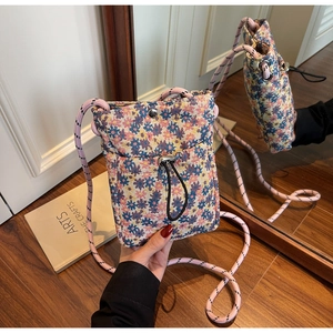 Mirror reflection showing floral fabric phone bag with pink rope strap and drawstring pocket